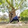 Woman in a warrior pose under a tree